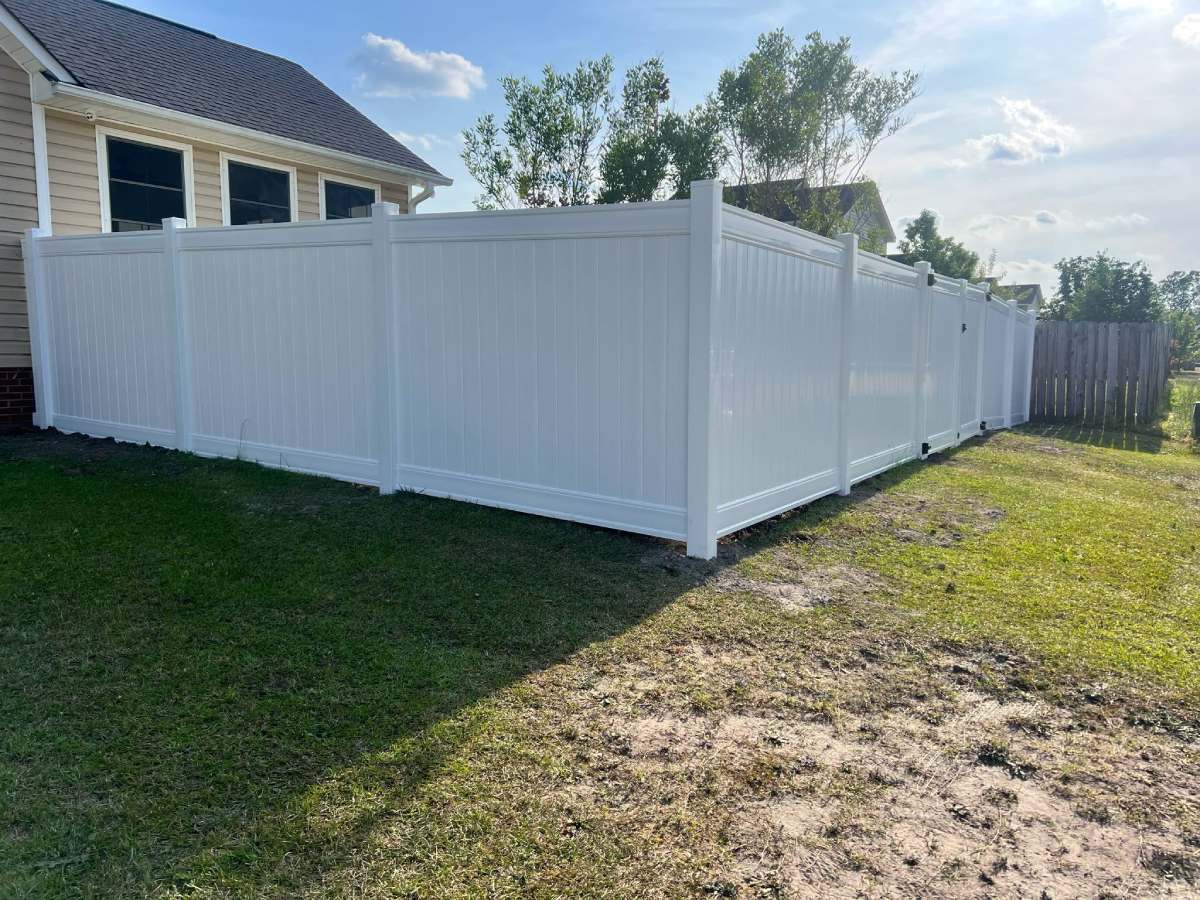 No-dig white vinyl privacy fence installation by Dynamic Fence Company in Fayetteville NC, offering durable, low-maintenance backyard privacy with efficient, post-free installation.