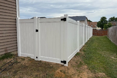 White vinyl privacy fence installed along side yard in Fayetteville, NC with clean panel design and secure gate hardware